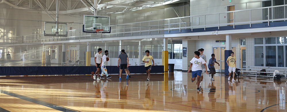 A group of young men playing basketball at a CRC court.